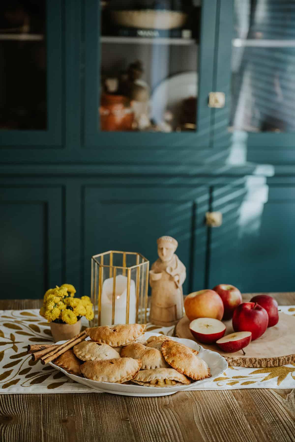 apple pie empanadas displayed on a rustic wooden table