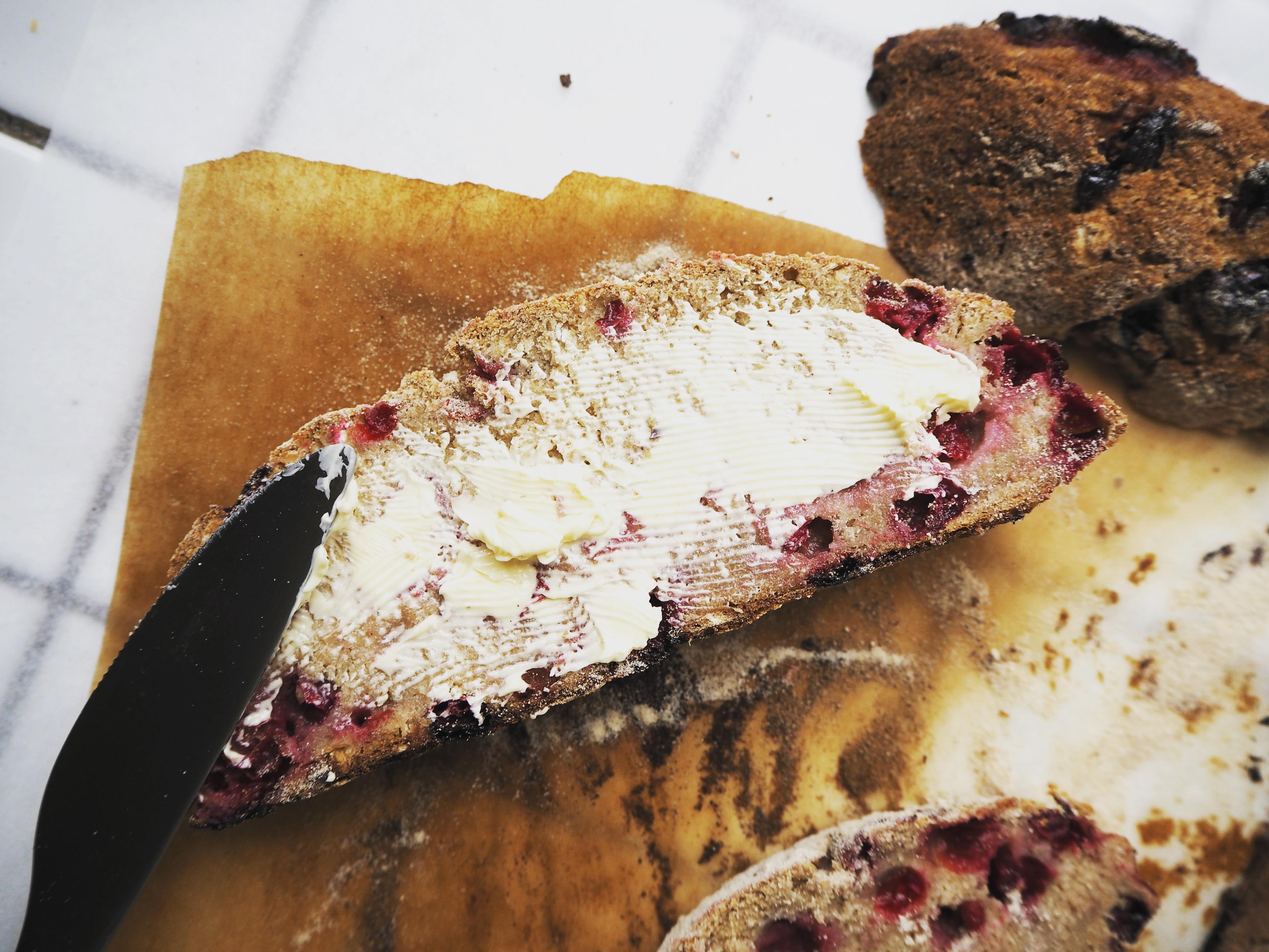 Close-up of lingonberry jam being spread on a freshly baked flatbread