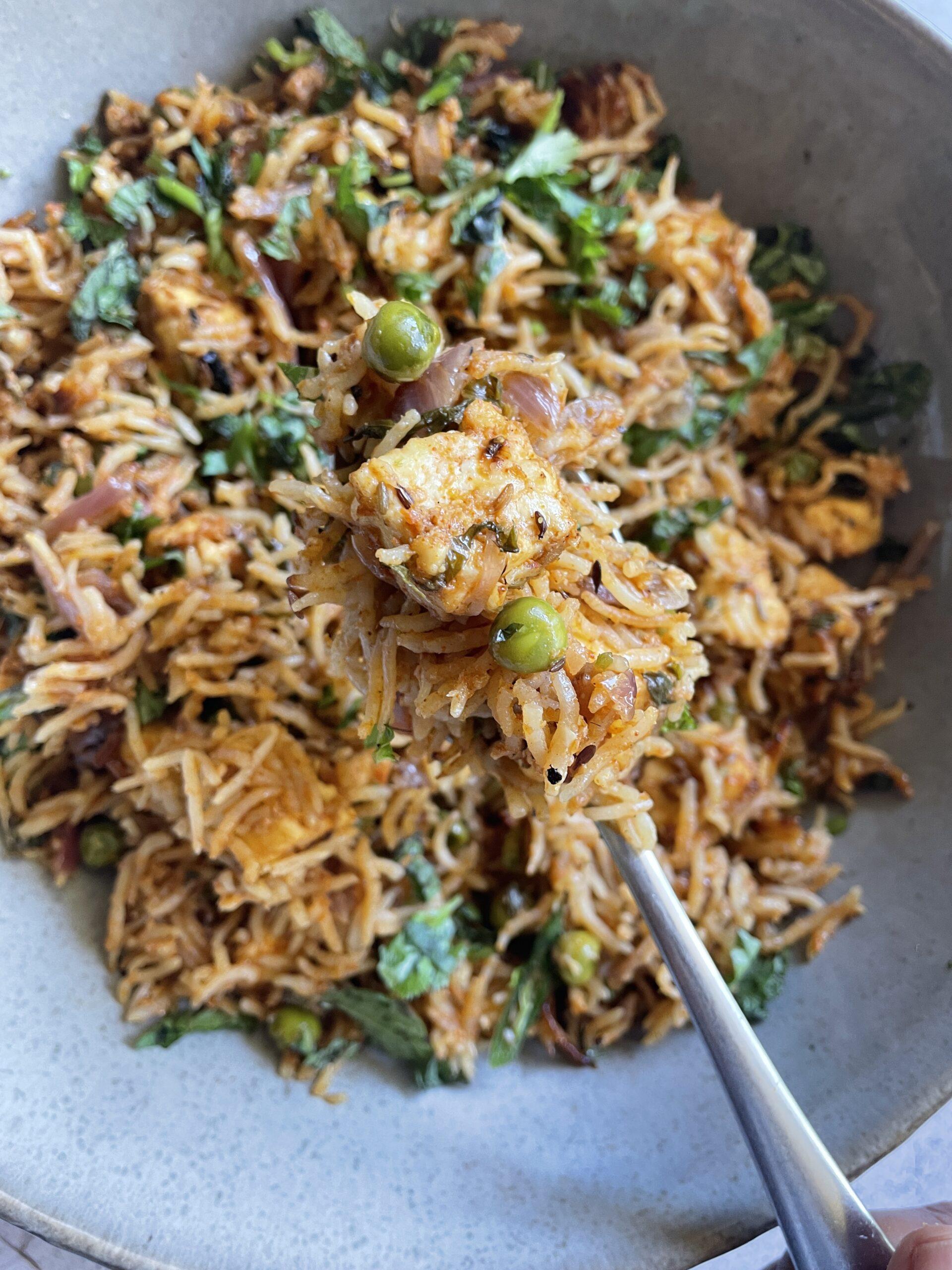 Overhead shot of Mutter Paneer Biryani being layered in a pot