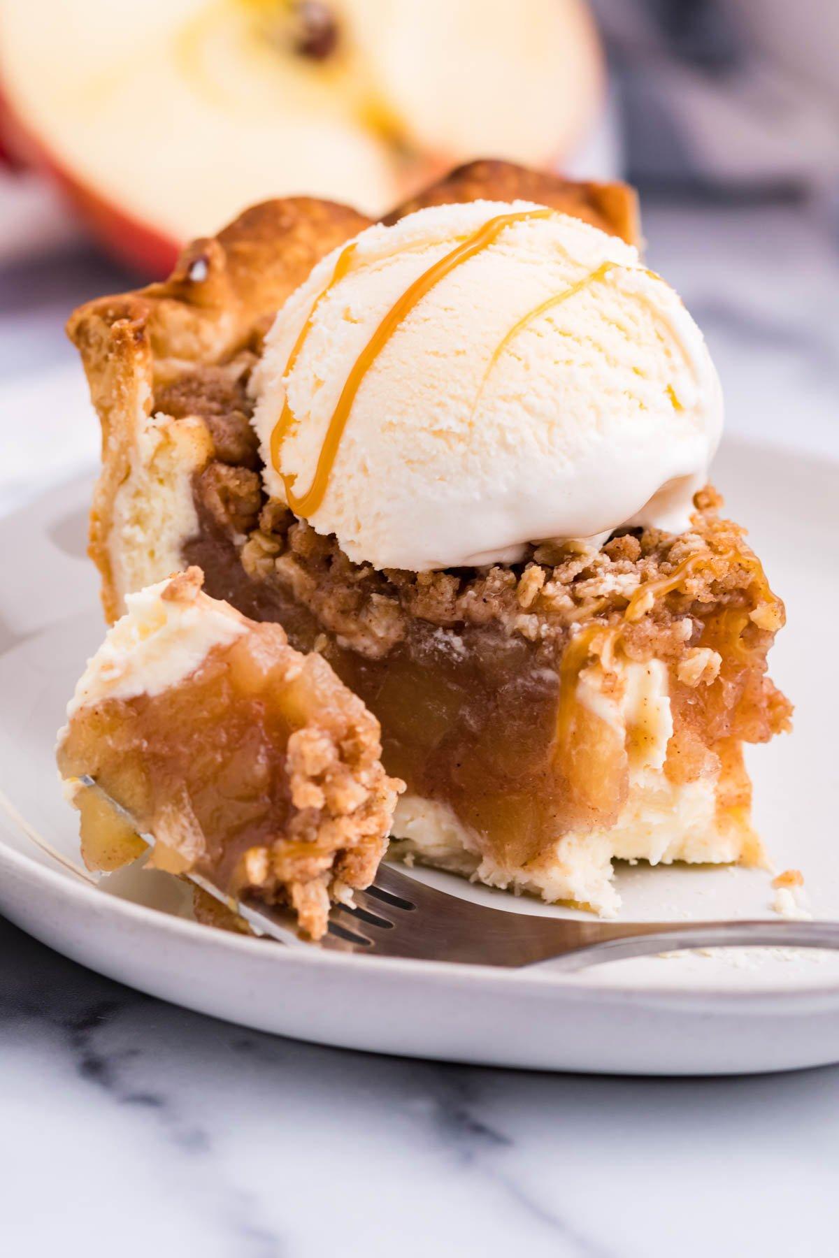 A slice of Apple Crisp Cheesecake with a scoop of vanilla ice cream