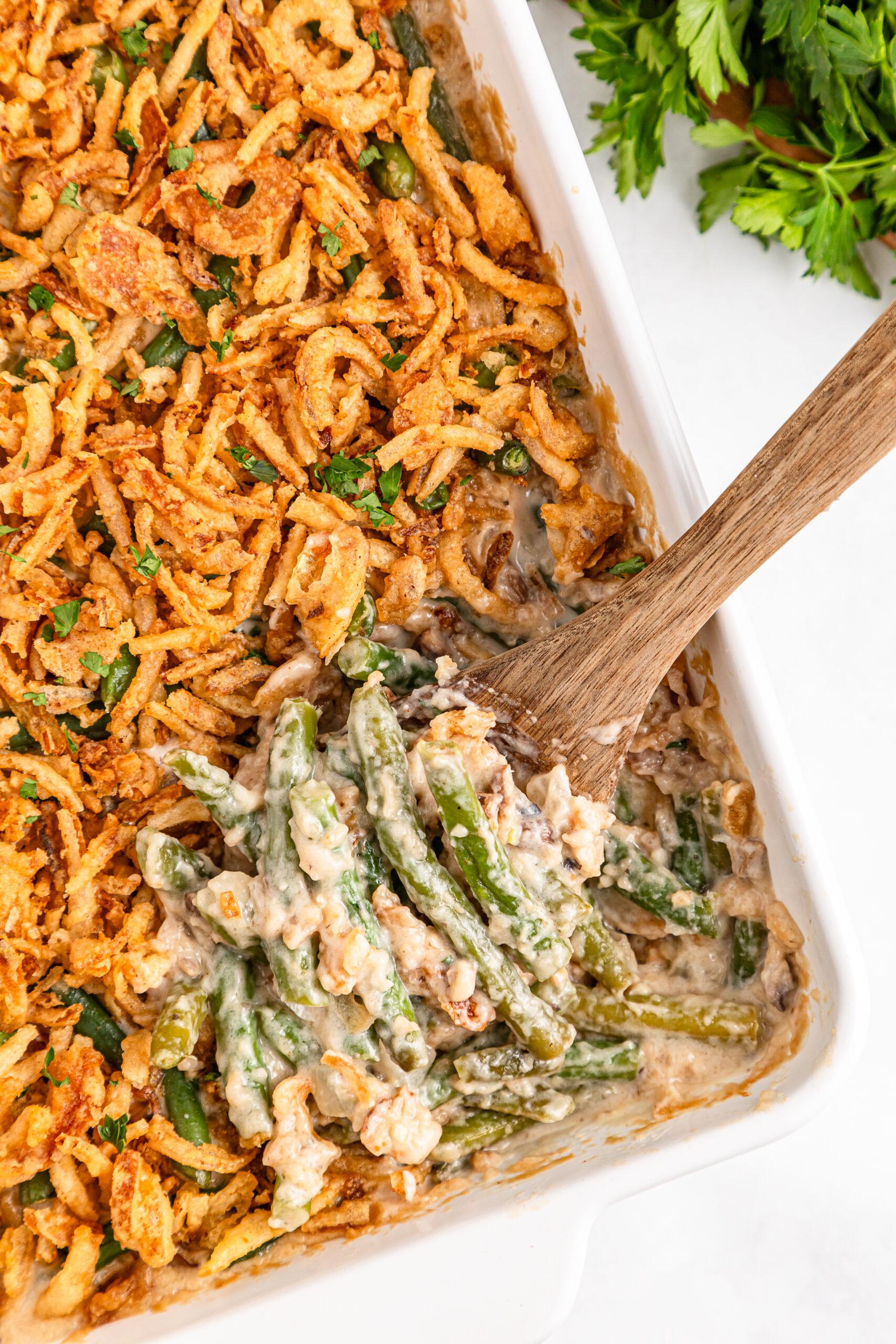 Delicious creamy green bean casserole with crispy onion topping, garnished, served on a holiday table