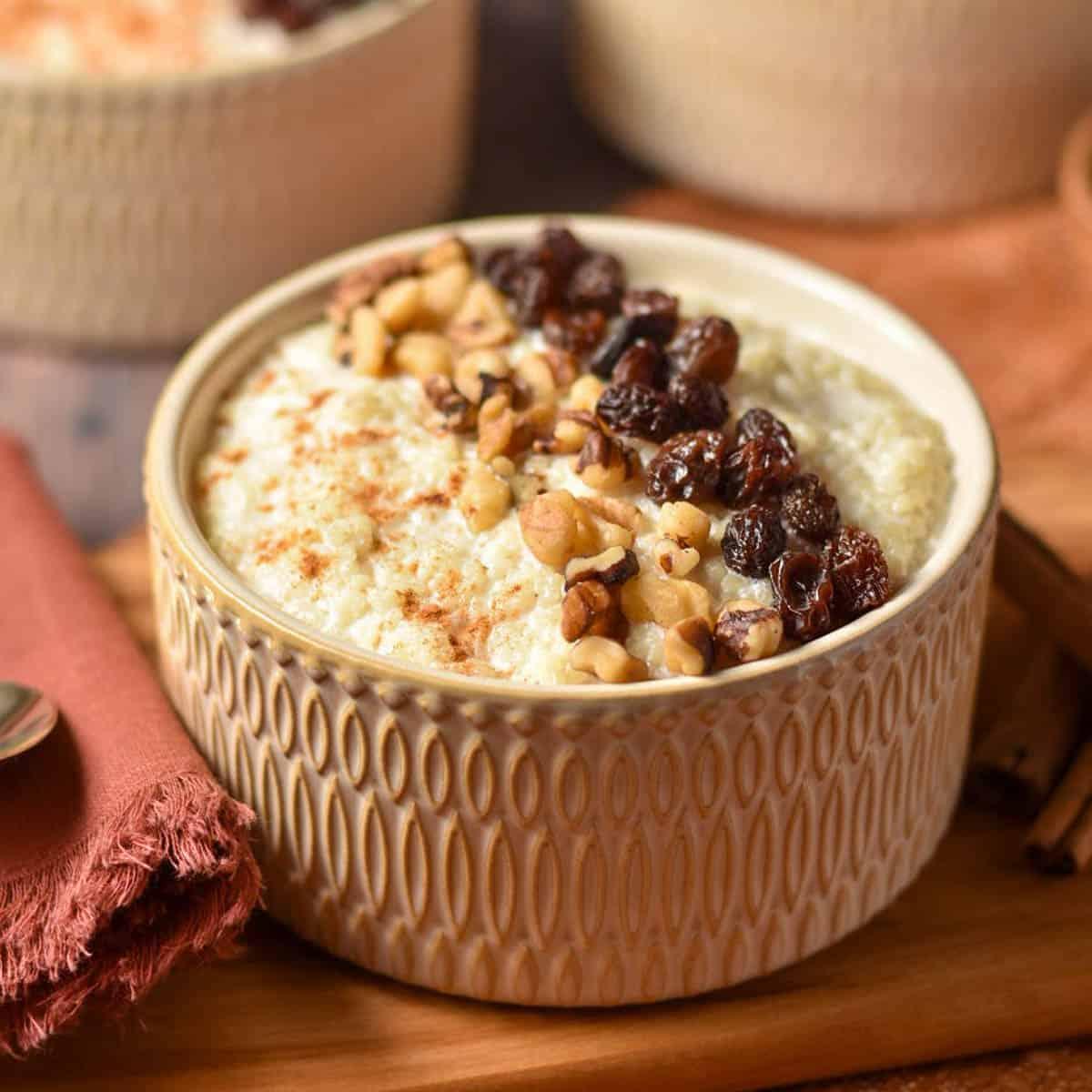 A rustic bowl of creamy wheat and semolina pudding, garnished with cinnamon and a sprinkle of nuts