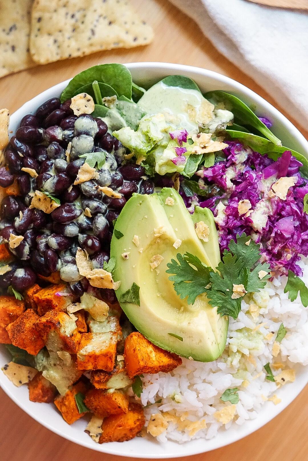 A rustic bowl of hearty roasted sweet potato and black bean stew, garnished with cilantro