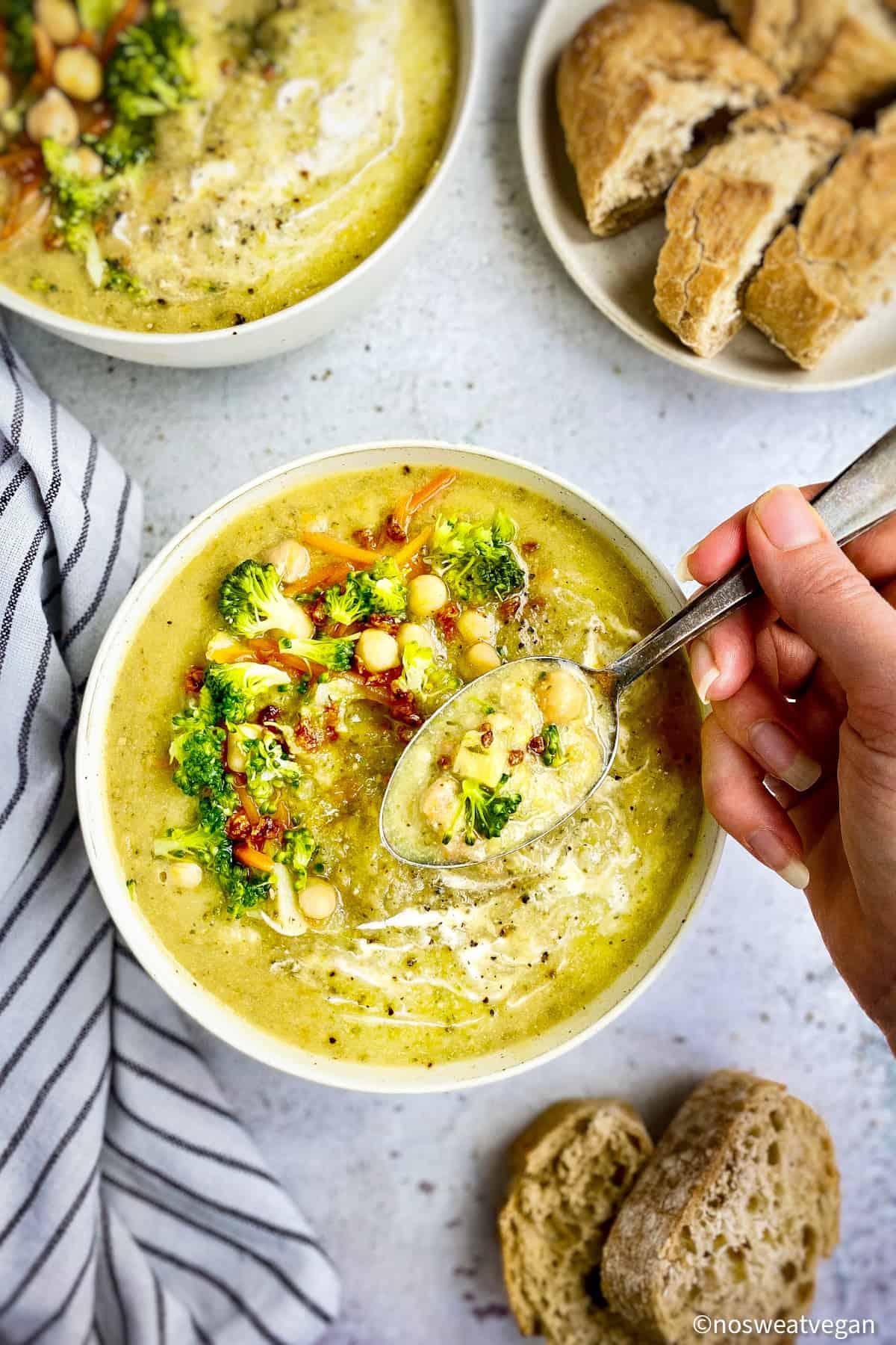 hand stirring a pot of creamy vegan broccoli soup