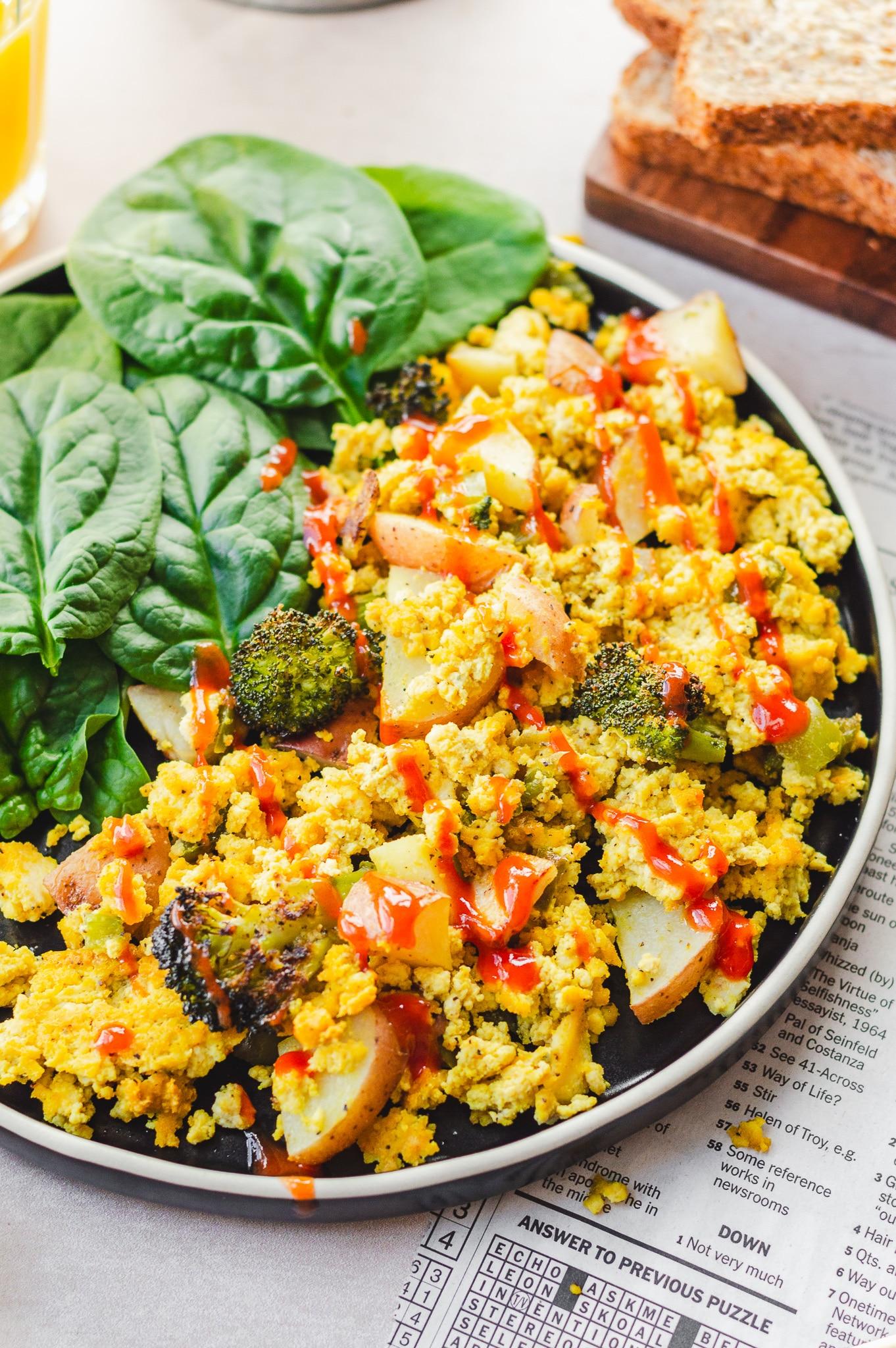 Overhead shot of a freshly baked tofu scramble frittata with vegetables on a rustic wooden table
