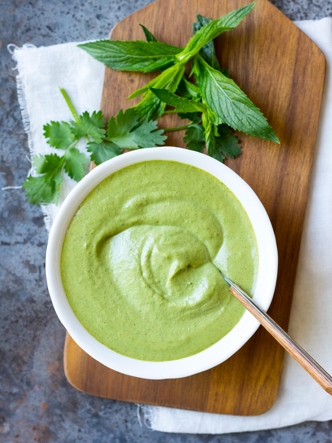 Bowl of creamy cashew sauce with fresh herbs.