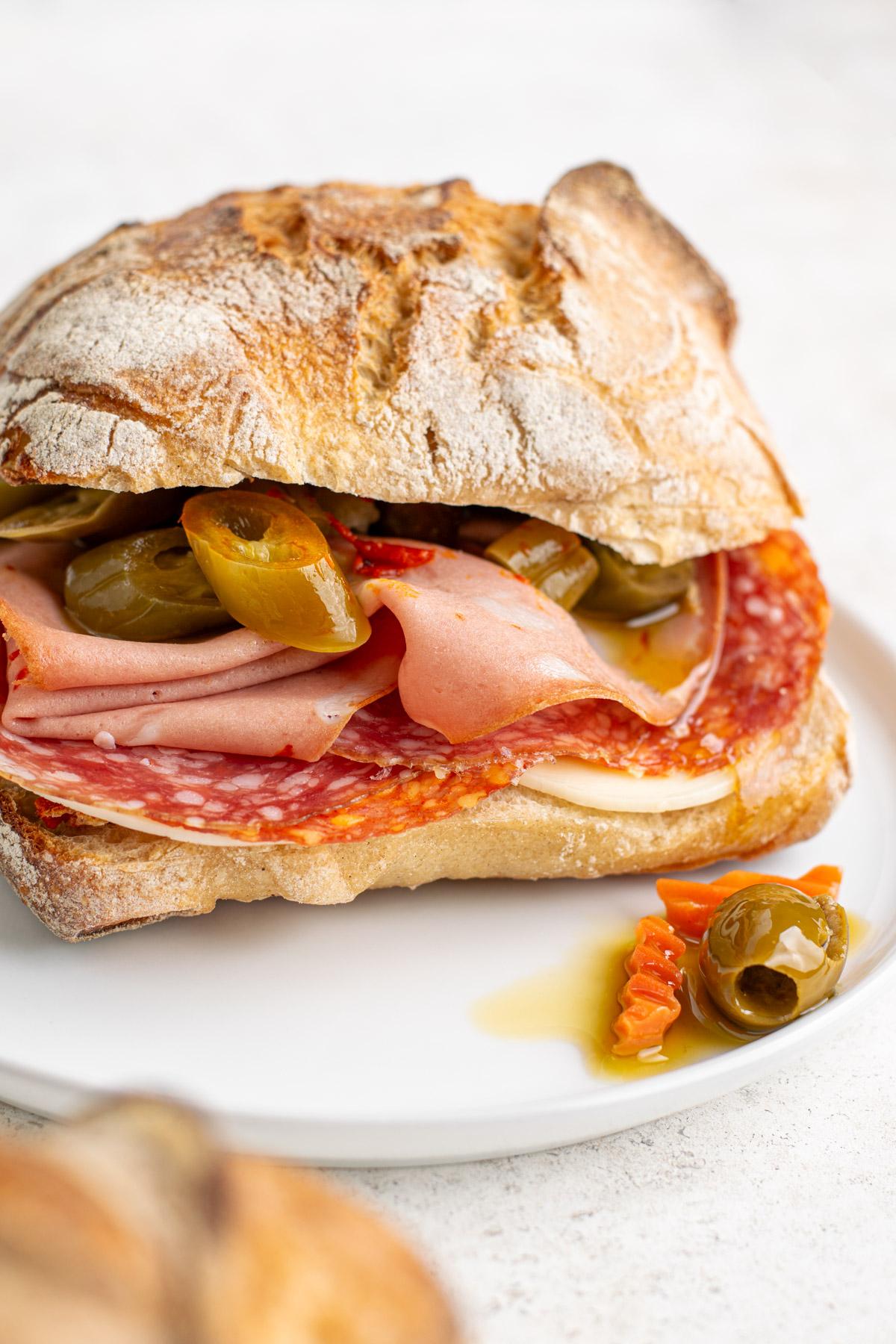 A tempting close-up shot of a halved Spicy Italian Panini, cheese stretching dramatically.
