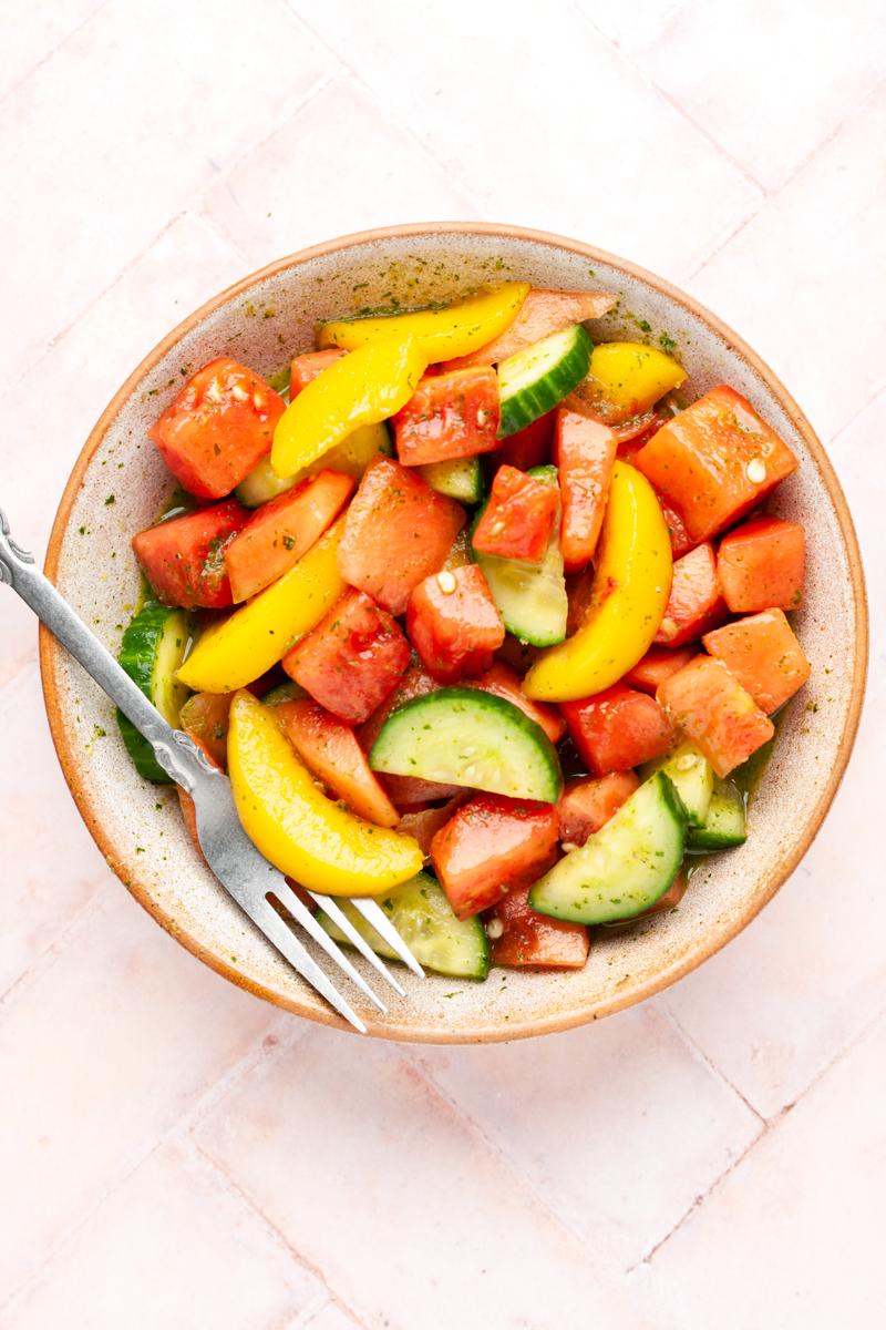 Watermelon and peach salad served in a rustic bowl