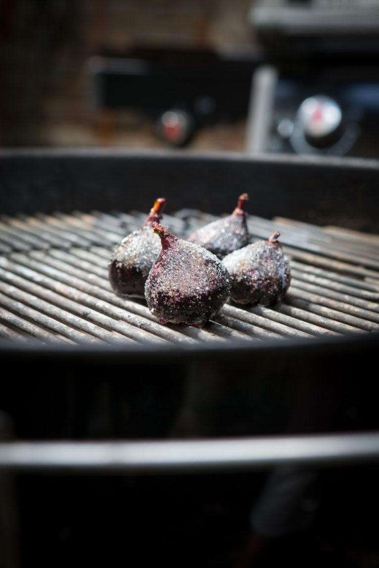 A person grilling steak and figs