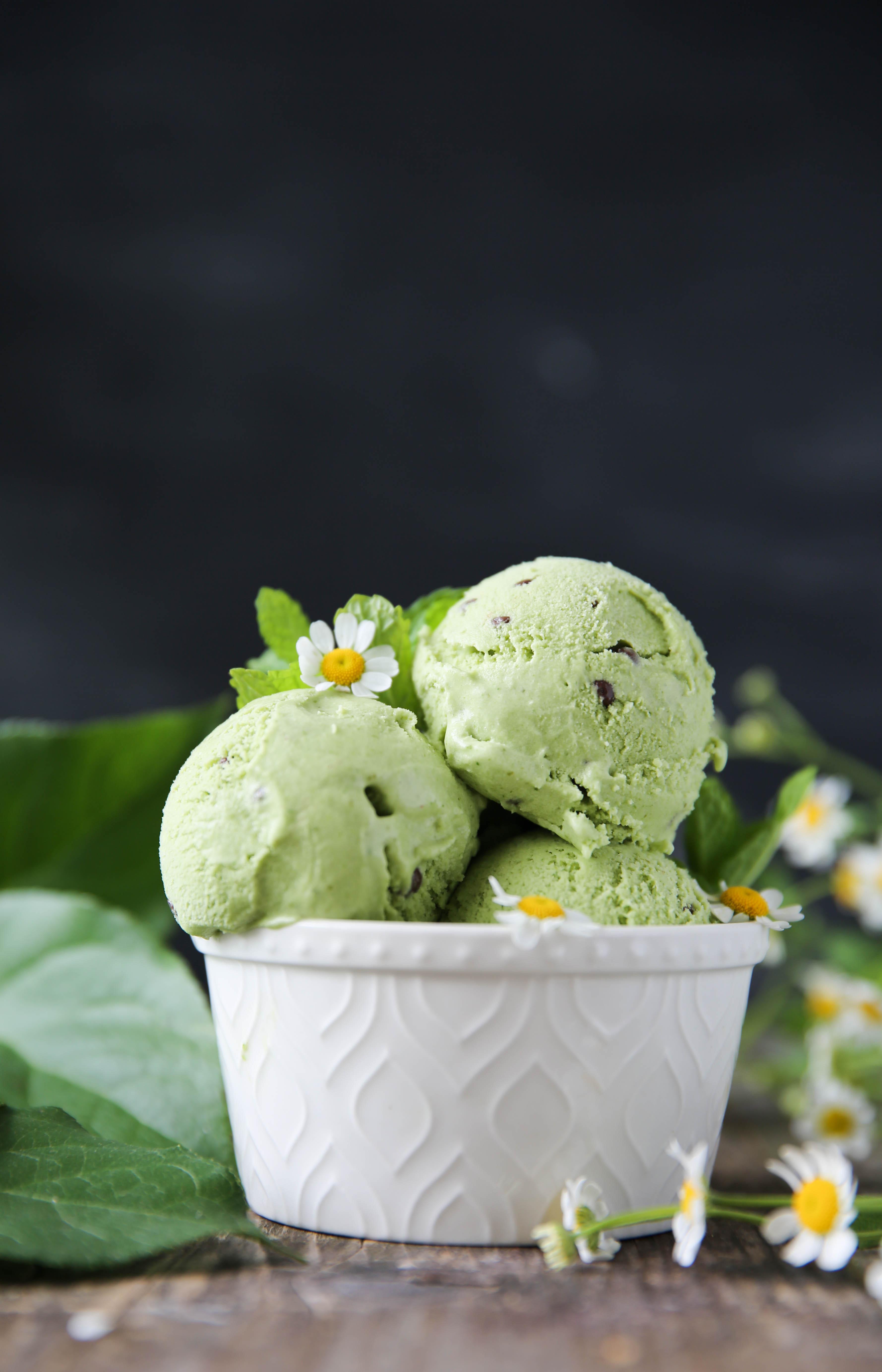 Person smiling and enjoying a bowl of mint chocolate chip ice cream