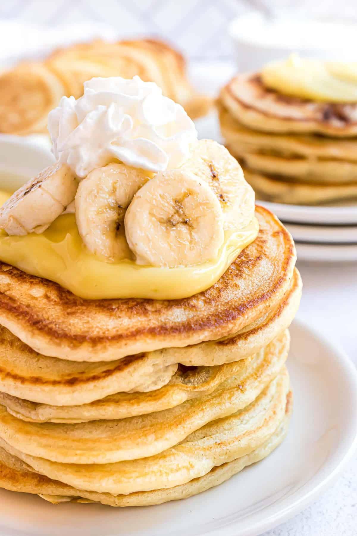 Close-up shot of a single banana pancake with whipped cream