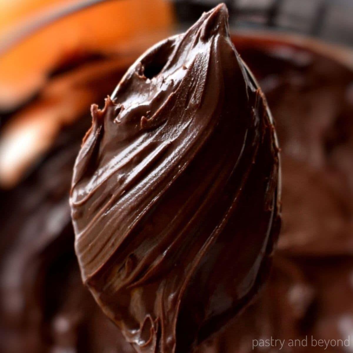 The chocolate ganache being poured onto the orange curd