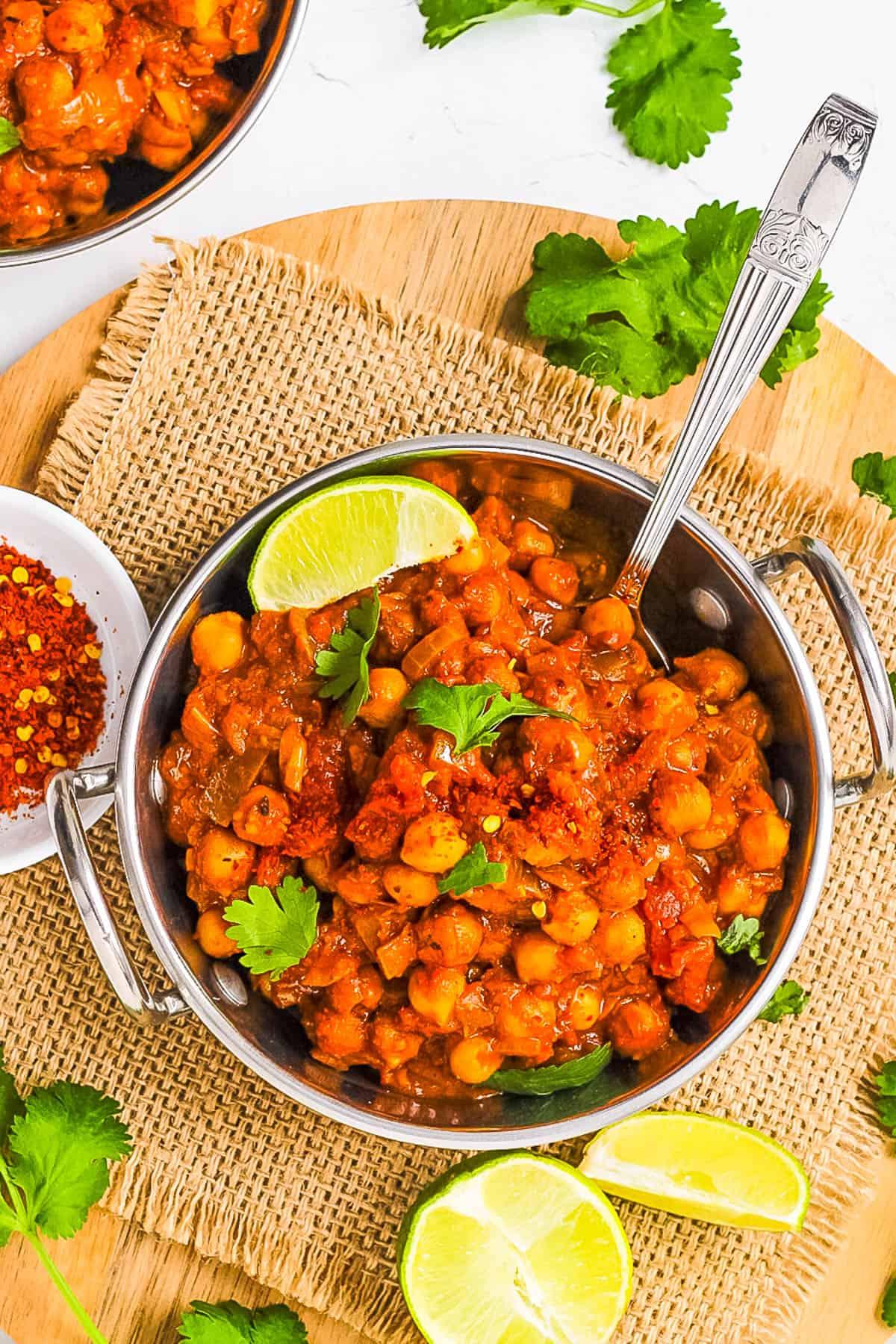 Aromatic and vibrant tomato and chickpea curry simmering in a pot, garnished with fresh cilantro and a sprinkle of chili flakes