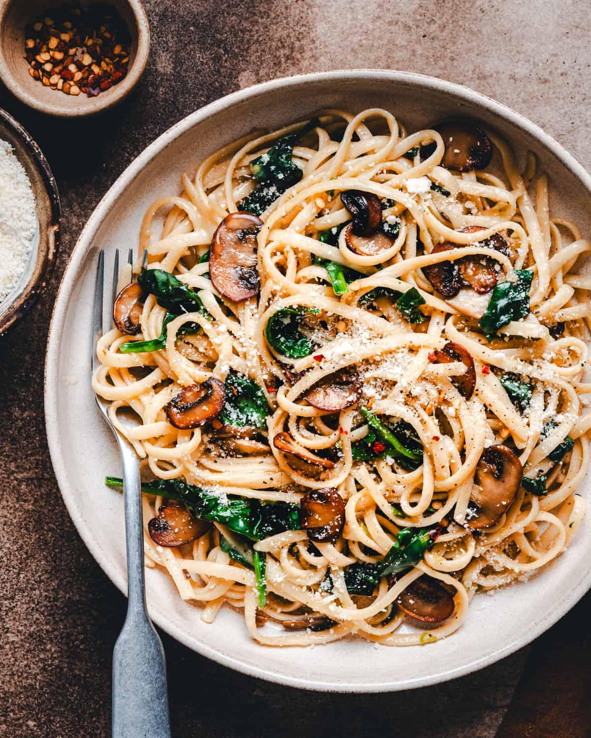 Close-up shot of a delicious pasta dish with vibrant vegetables and a sprinkle of Parmesan cheese.