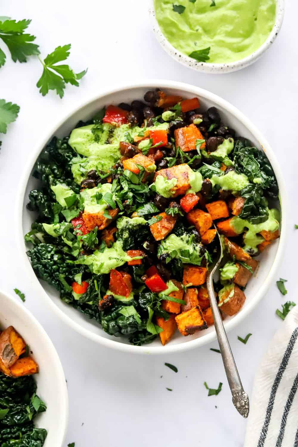 Close-up shot of a bowl of roasted sweet potato and black bean stew, showing the texture and color