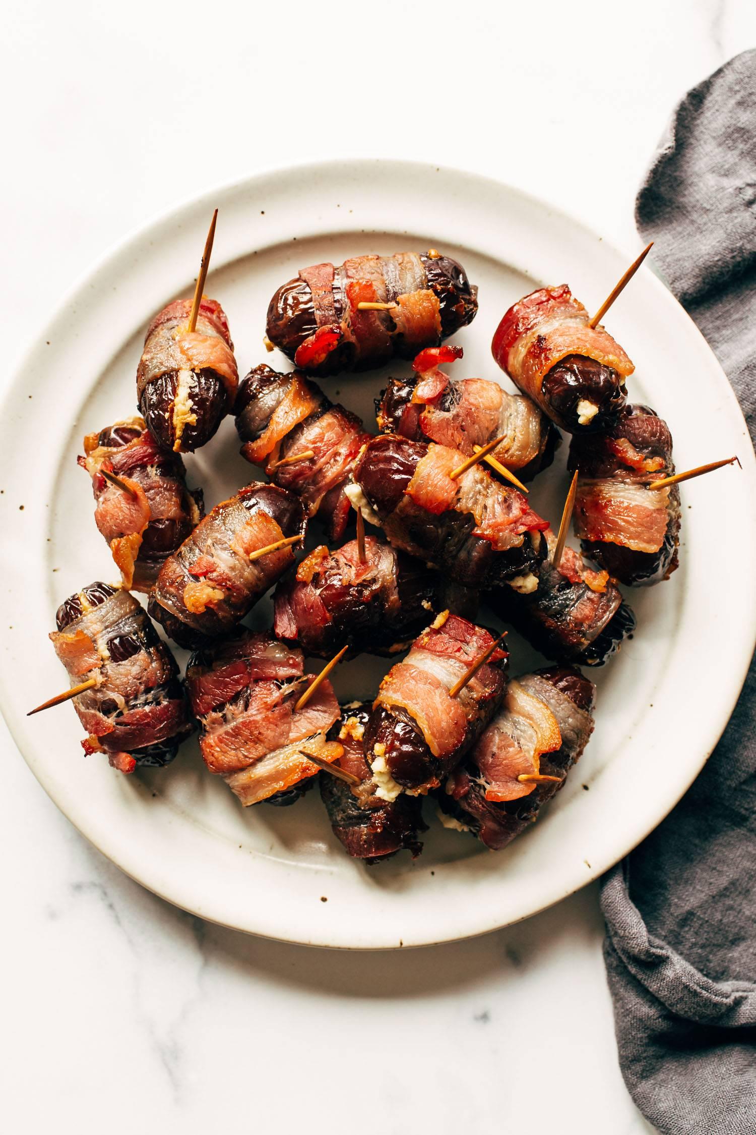 Close-up shot of bacon-wrapped dates stuffed with goat cheese, glistening from the oven