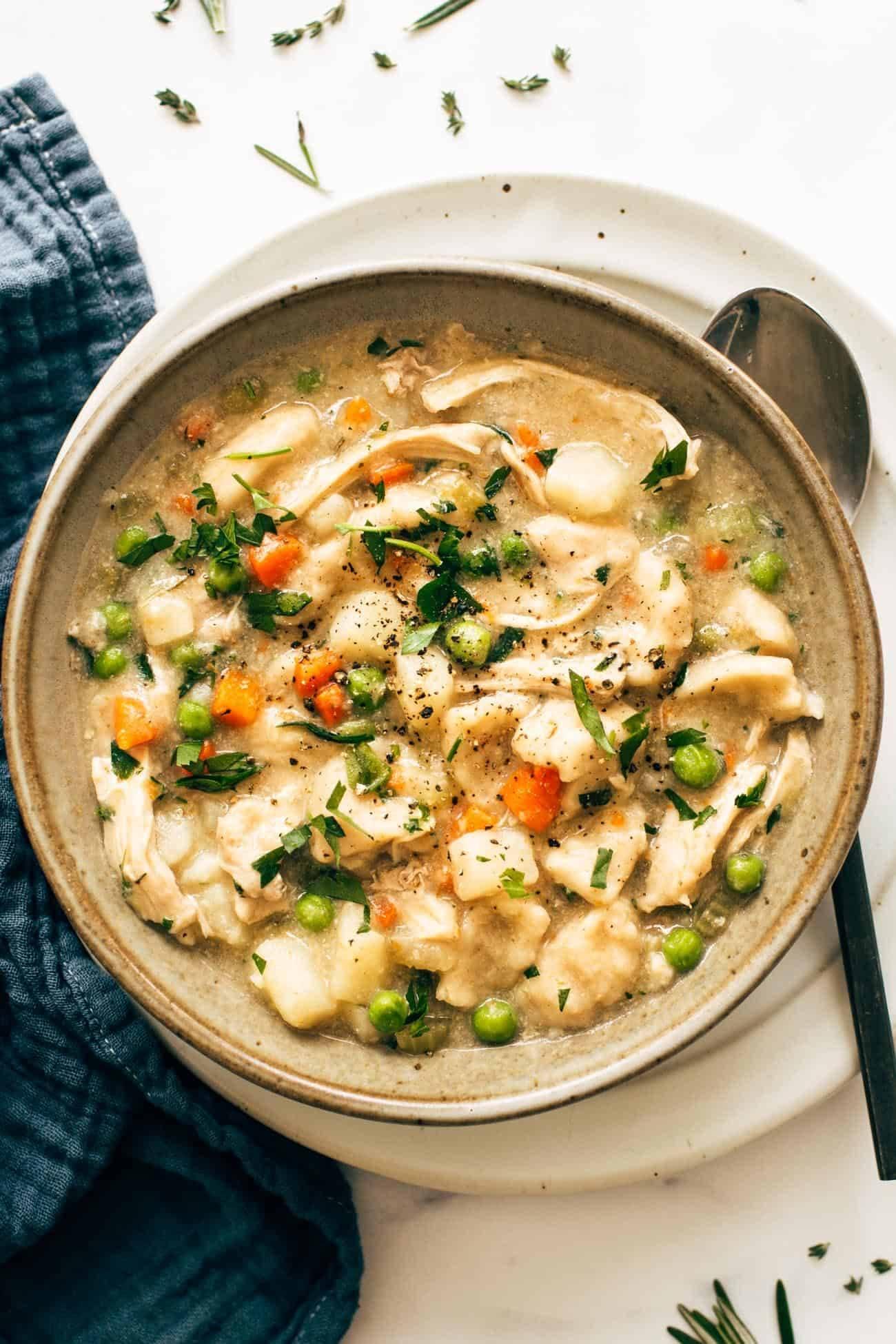Close-up shot of a bowl of Instant Pot Chicken and Dumpling Soup with Thyme, showing the texture of the dumplings and the vibrant color of the soup.