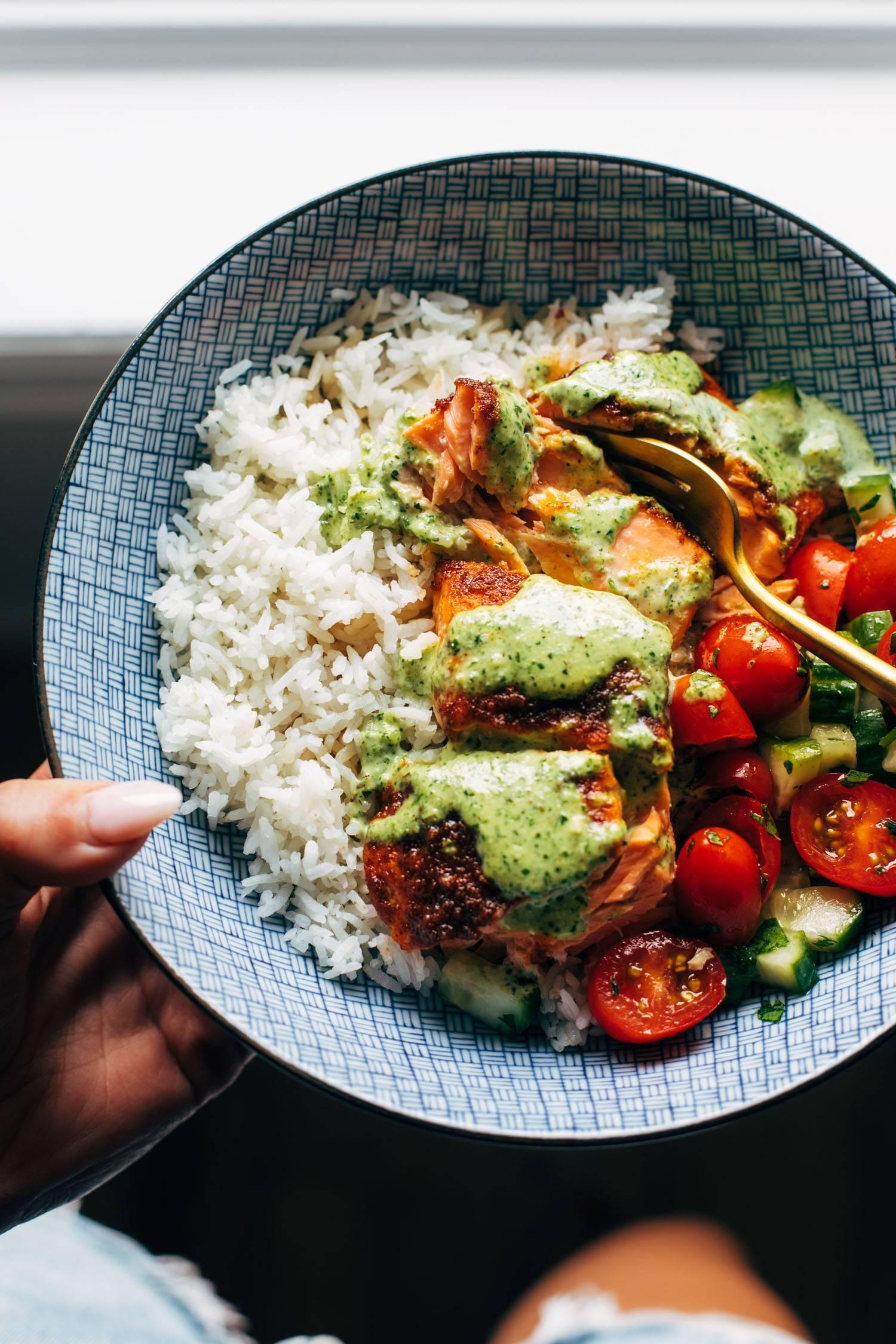 A person enjoying a plate of basil-garlic salmon
