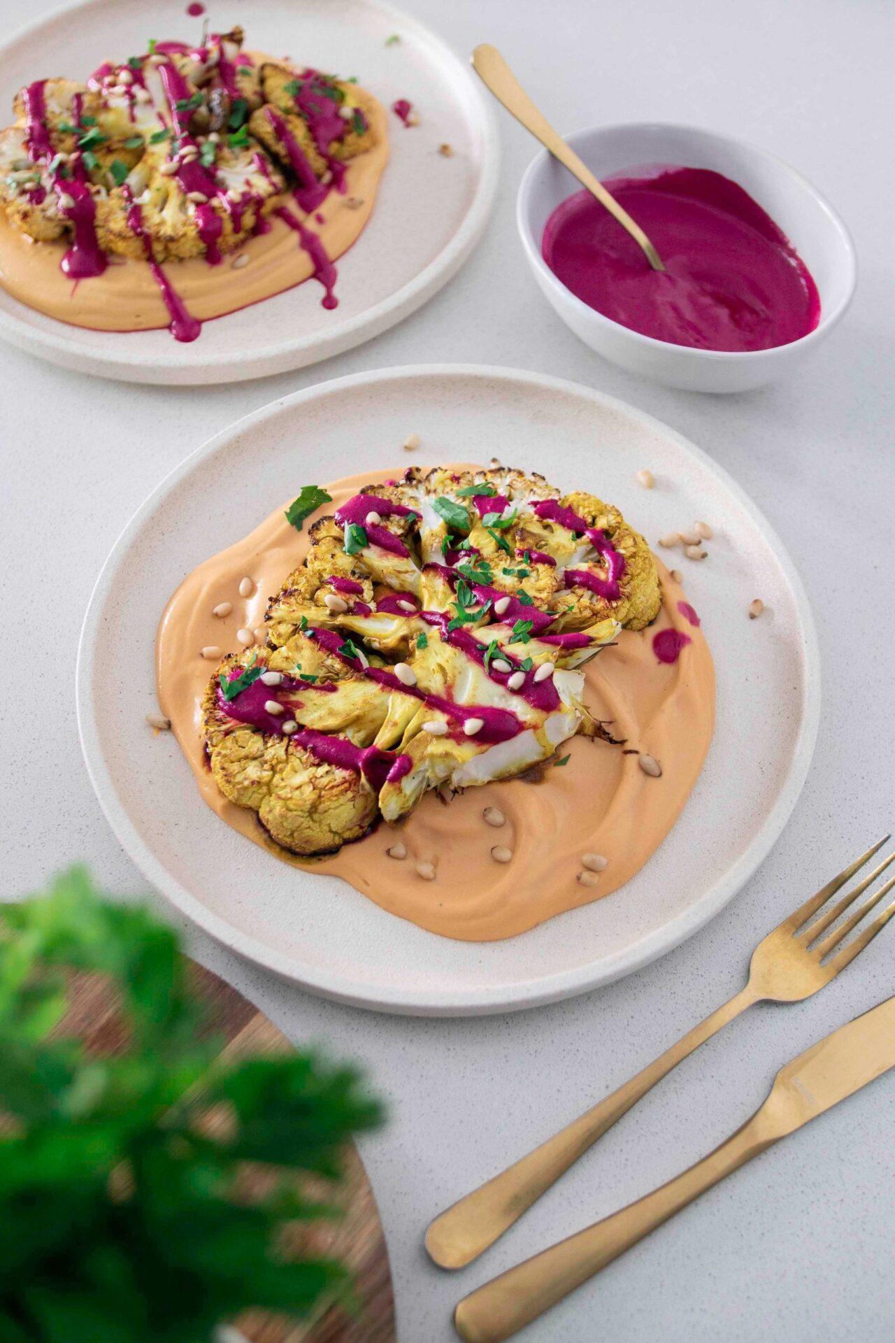 A rustic table setting with a plate of Cauliflower Steaks with Beetroot and Orange, highlighting the vibrant colors and textures.