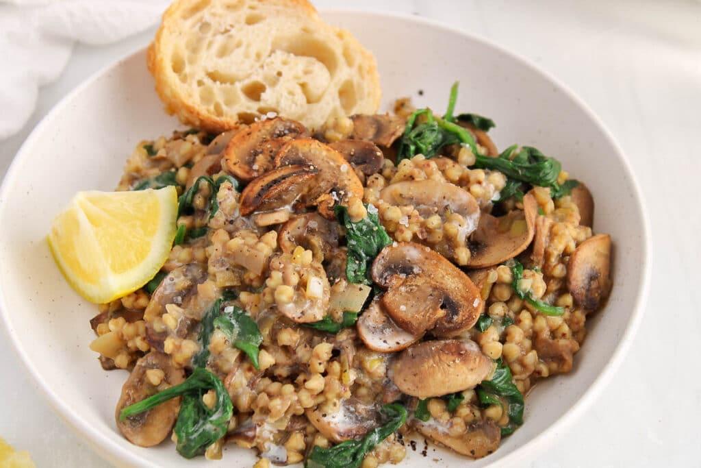 A rustic kitchen setting with a steaming bowl of Creamy Spinach and Mushroom Risotto in the foreground