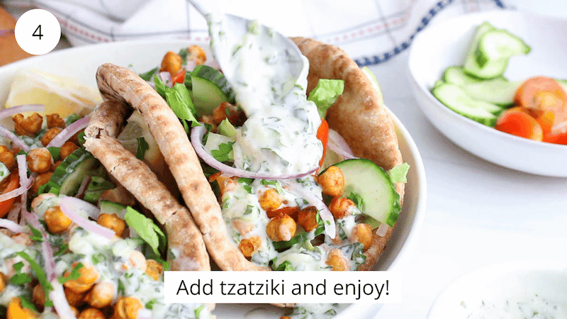 Close-up shot of a gyro with spiced chickpeas and tahini sauce being held