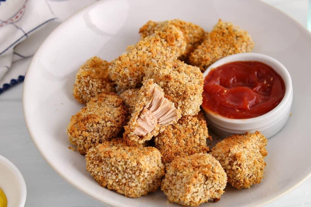 close-up shot of crispy fried jackfruit nuggets on a plate, garnished with fresh herbs