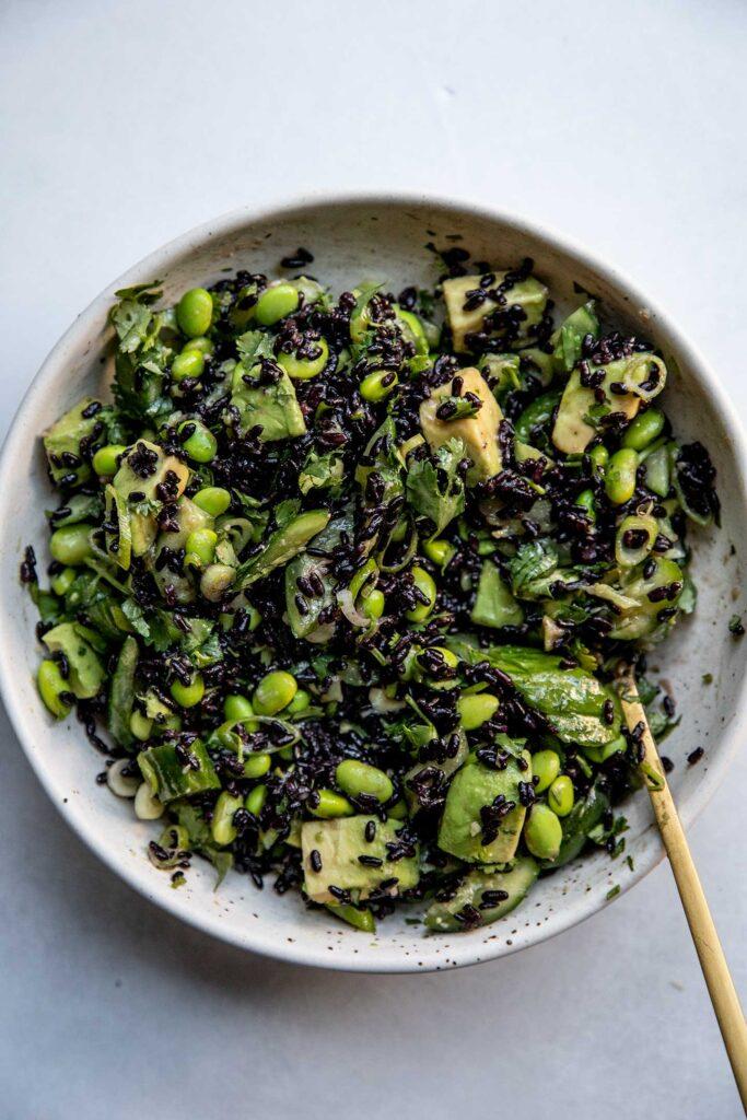 Close-up shot showcasing the texture of the black rice, edamame, and avocado