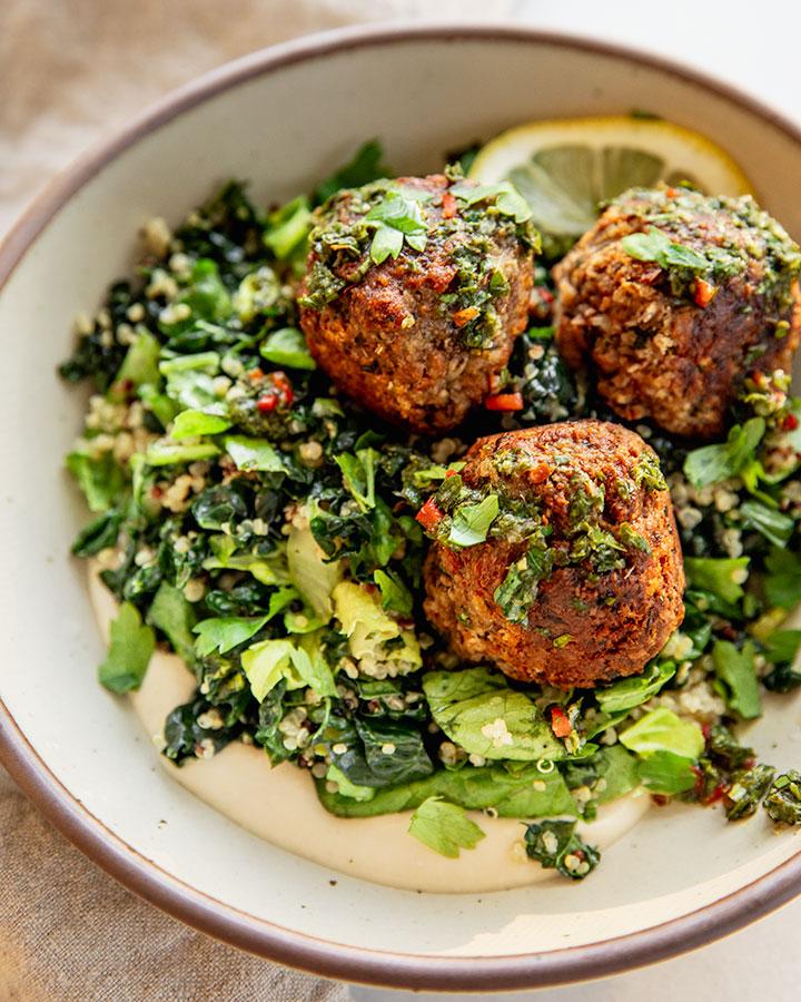 Plant-based meatball sauerbraten served in a rustic bowl with a sprig of fresh parsley