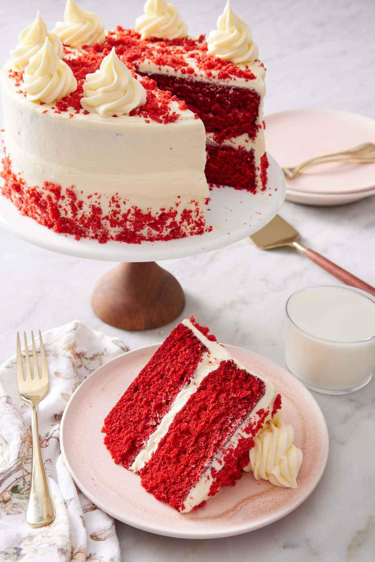 A whole red velvet cake on a cake stand, ready to be served