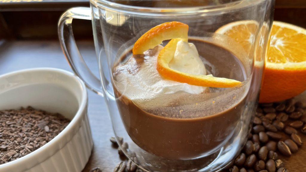Steaming hot chocolate mug with orange peel curl on top