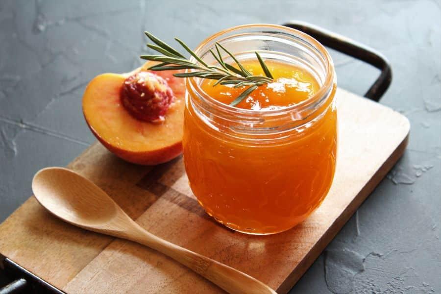 Close-up of a spoonful of rosemary peach preserves showing the texture