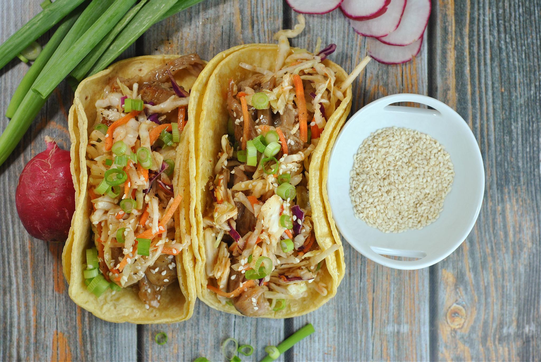 Overhead shot of assembled kimchi chive charm tacos on a serving platter