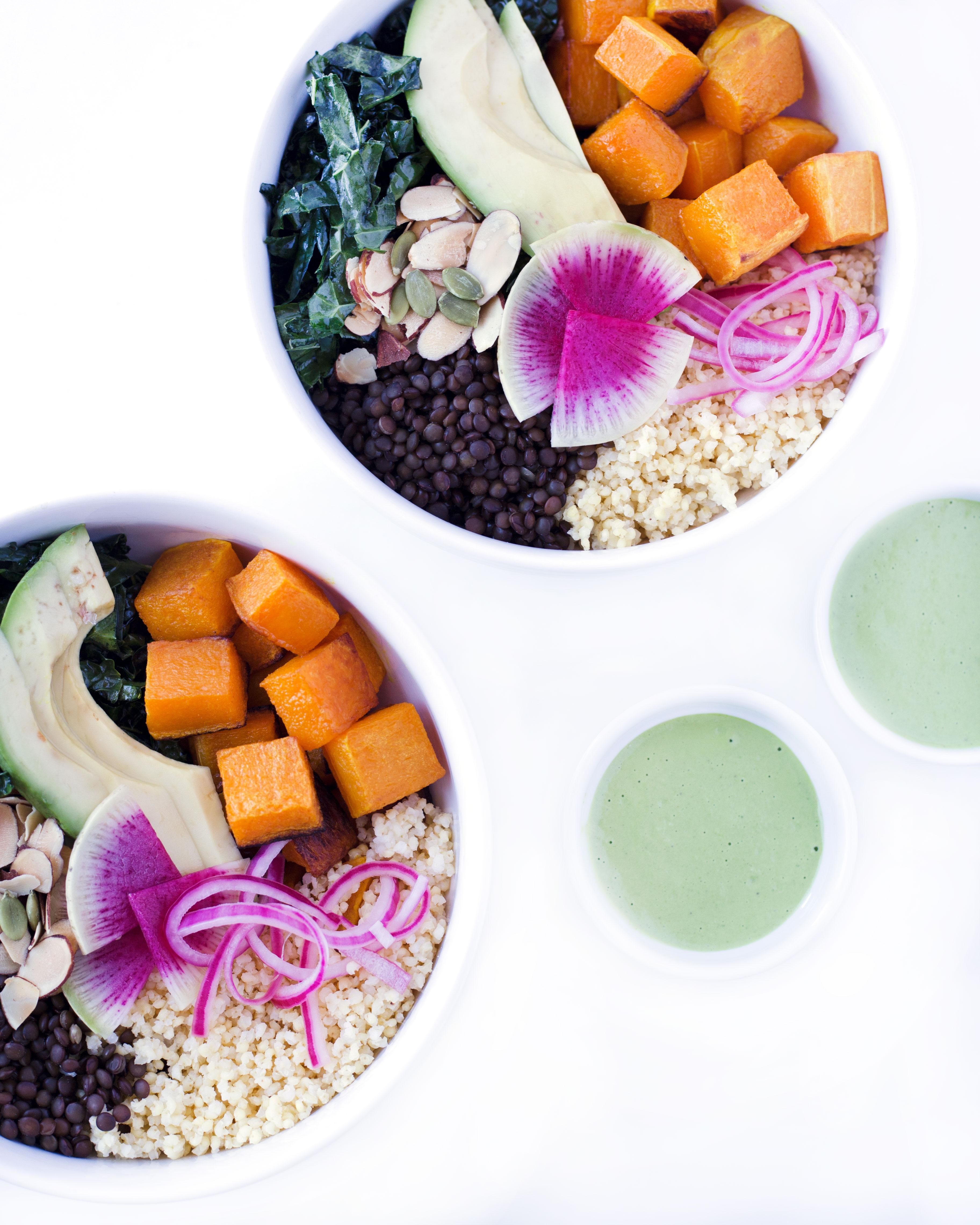 close-up shot of the dressing being drizzled over the vegan power bowl, highlighting the spirulina powder