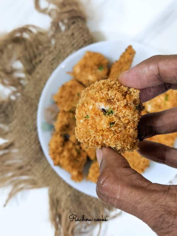 A close up of a handful of golden brown chicken nuggets