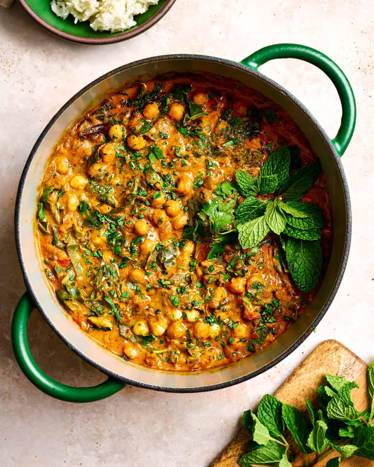 A vibrant and appetizing bowl of chickpea curry with colorful radishes, garnished with cilantro