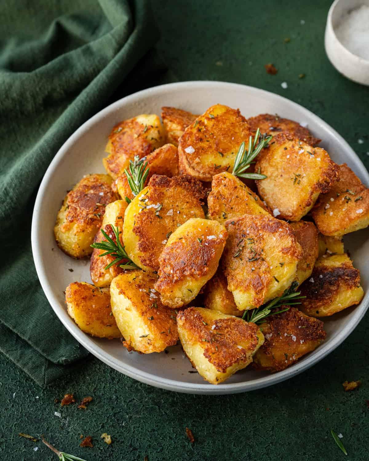 A close-up shot of crispy roasted potatoes with garlic and onion powder, seasoned perfectly and showing appetizing texture.