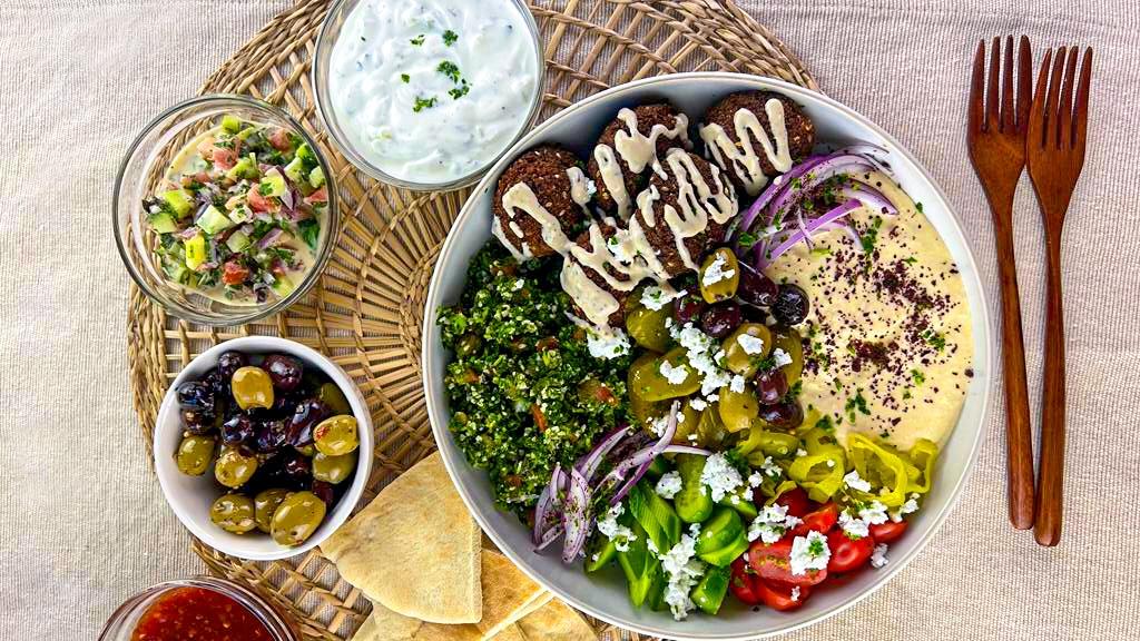 A table set for a meal featuring the falafel and olive salad