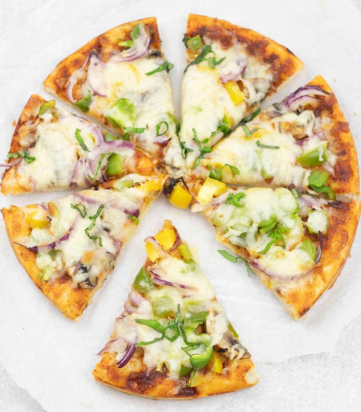 Person taking a slice of green curry pizza