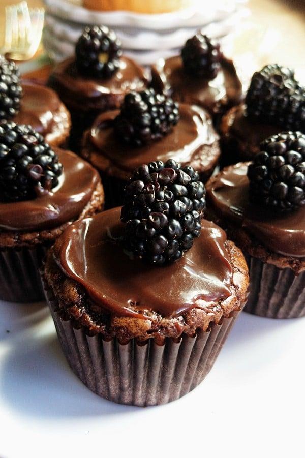 Close-up shot of gooey brownie bites with a blackberry swirl, garnished with fresh blackberries.