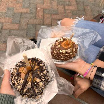A person's hands carefully placing caramel apple pecan clusters into an airtight container