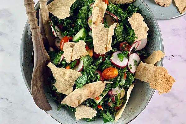 A person enjoying a bowl of Kale and Pistachio Fattoush outdoors