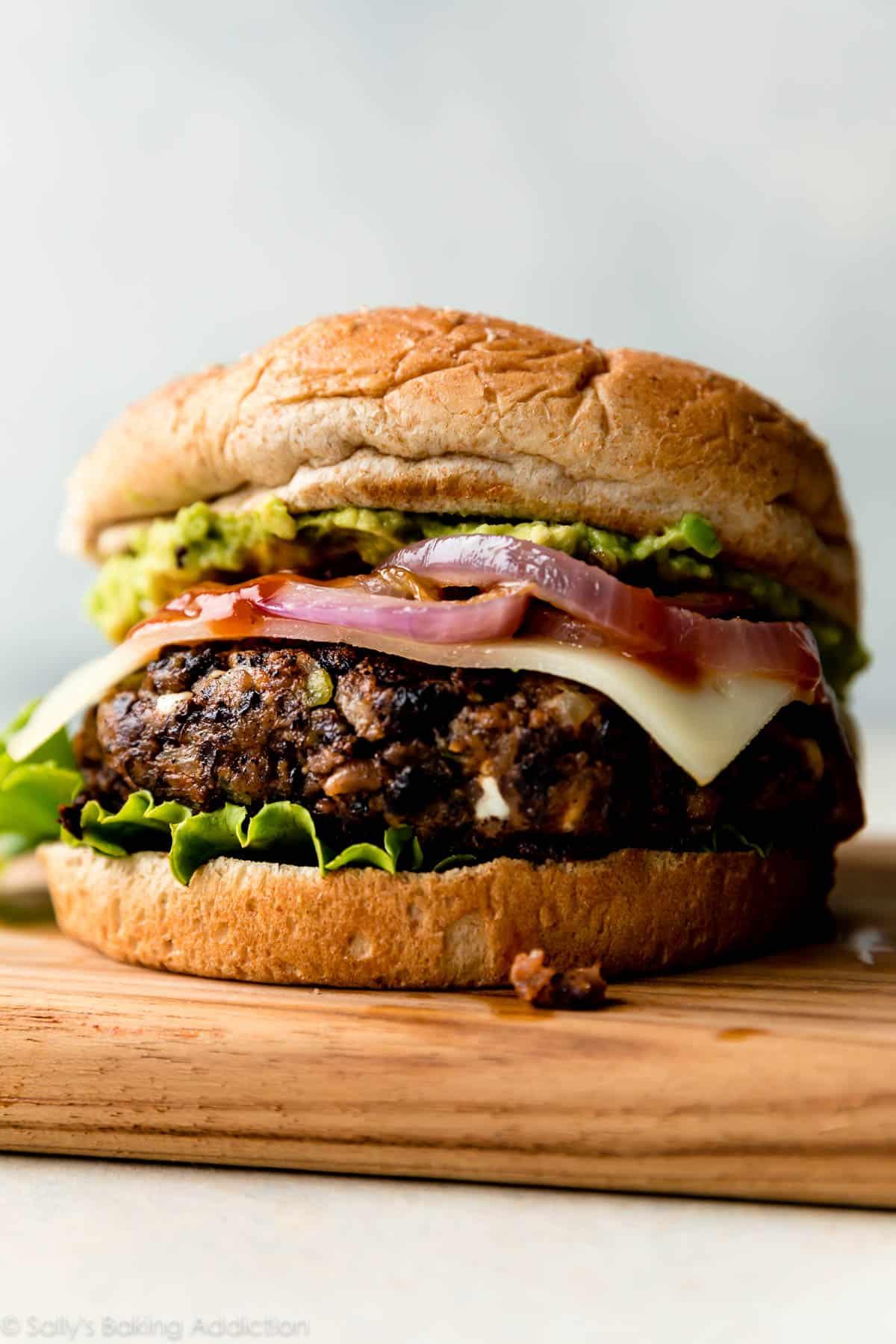 side view of a stack of roasted vegetable and black bean burgers, cut in half to show the texture