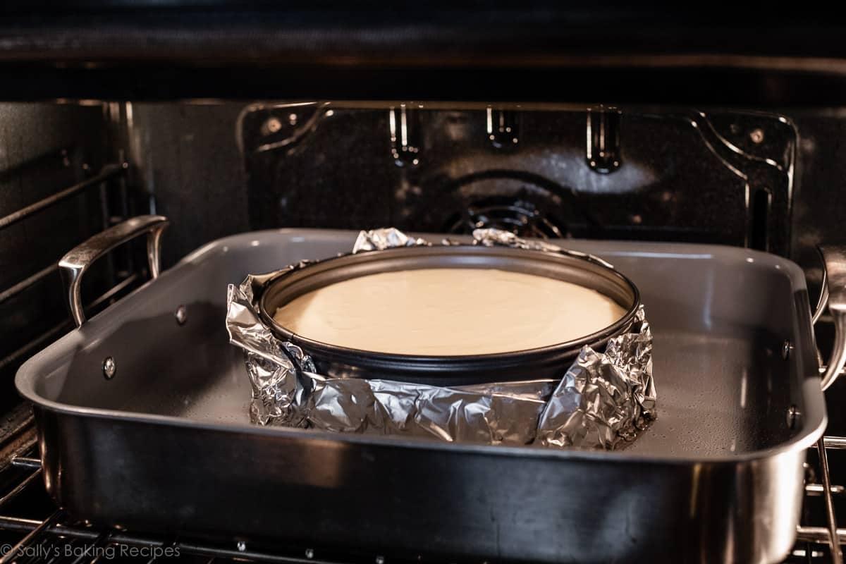 Cheesecake being baked in a water bath in the oven