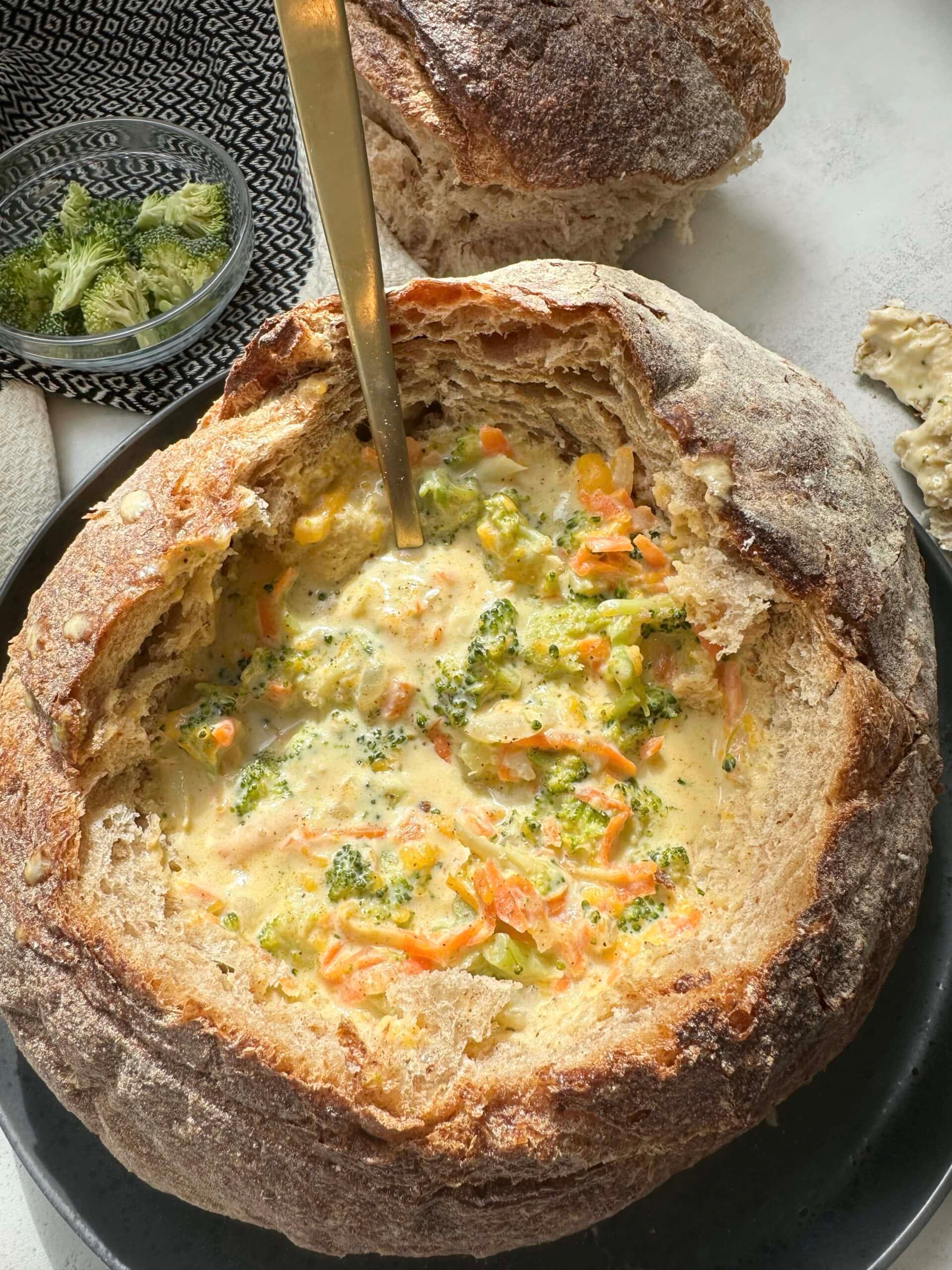 Close-up shot of a steaming bowl of creamy broccoli cheddar soup with crispy breadcrumbs
