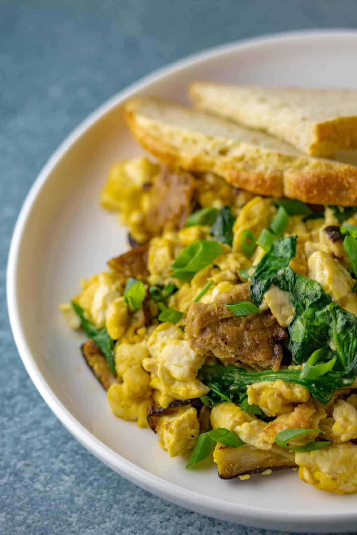 A vibrant and appetizing image of fluffy tofu scramble with herbs in a skillet, garnished with fresh herbs.