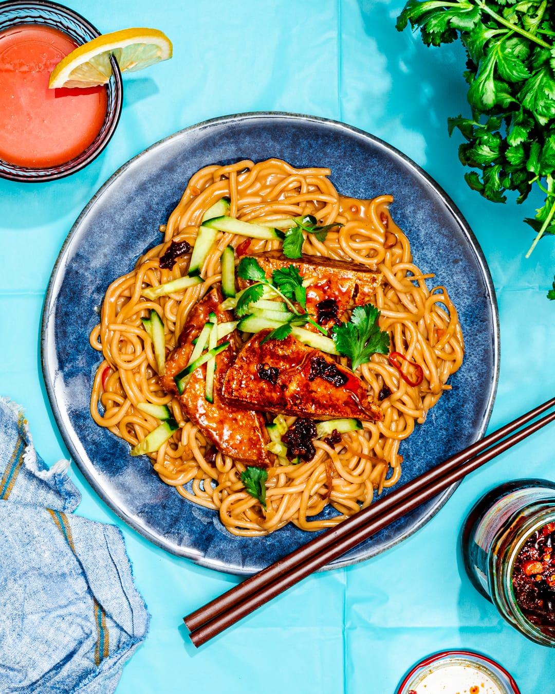 close up shot of spicy peanut noodles with tofu wrap on a plate