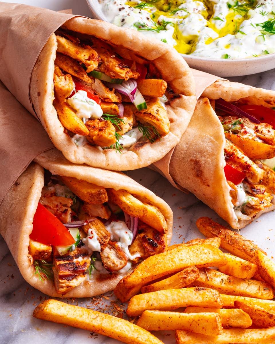 A vegan gyro, fully assembled, with a side of homemade fries