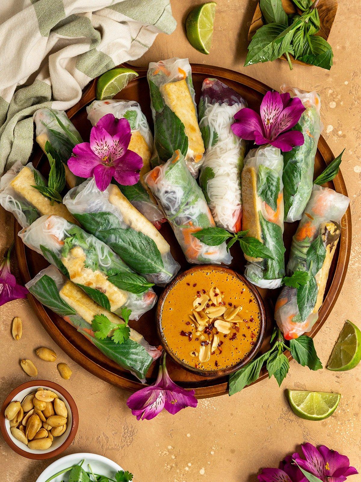 A platter of spring rolls garnished with fresh herbs
