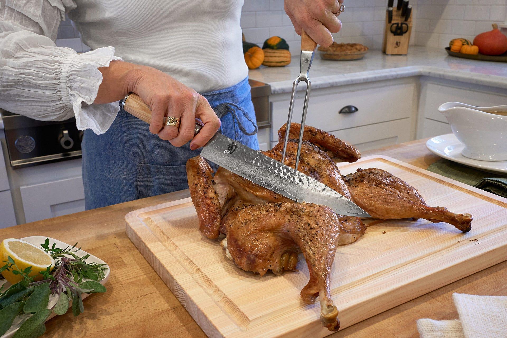 Chef's hands expertly carving a roasted turkey on a wooden cutting board, steam rising