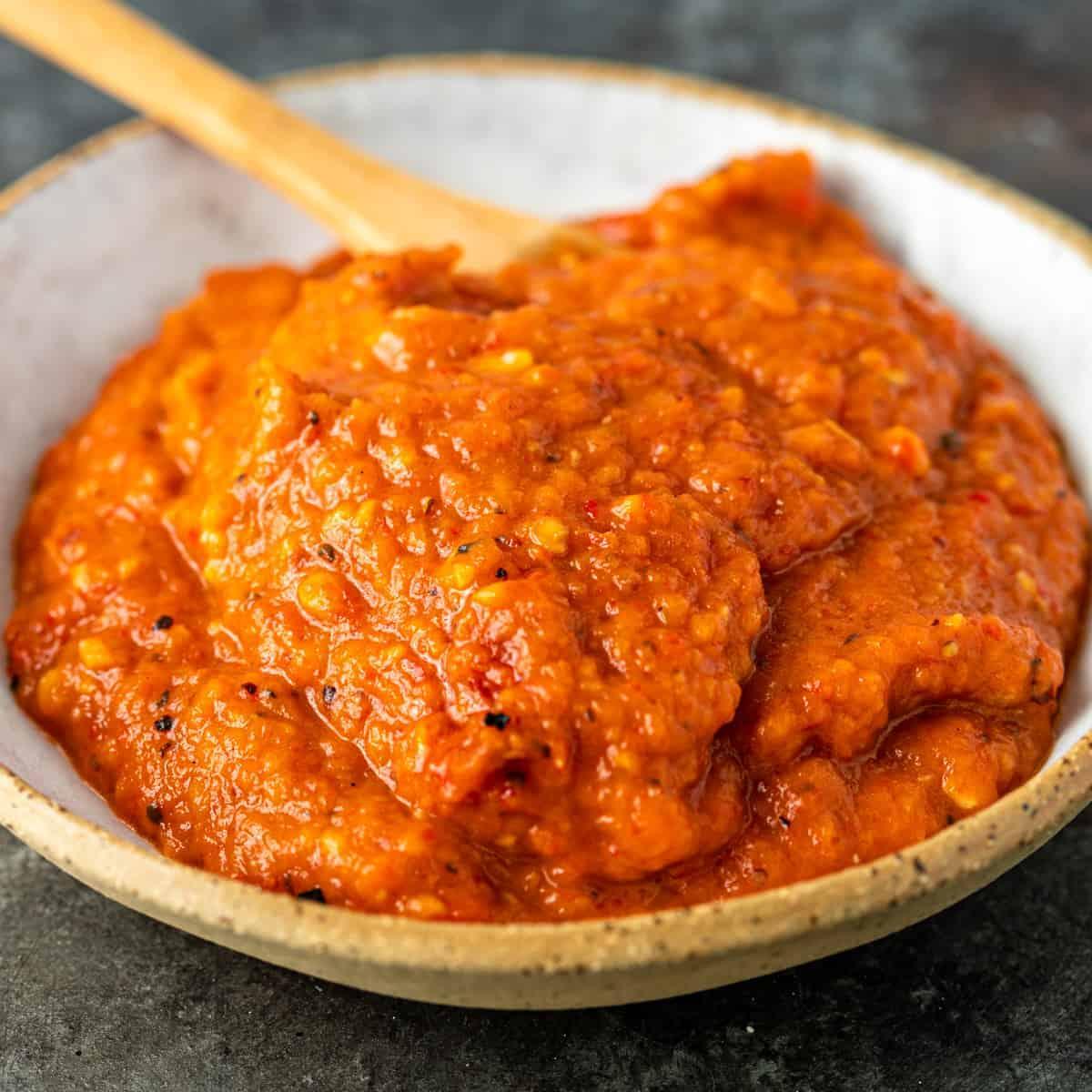 Close-up shot of a bowl with ajvar roasted red pepper peel chips